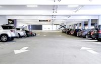 a group of cars sit in the parking lot in an indoor space with white walls