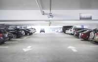 a group of cars sit in the parking lot in an indoor space with white walls