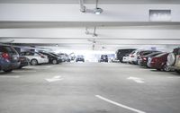 a group of cars sit in the parking lot in an indoor space with white walls