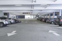 a group of cars sit in the parking lot in an indoor space with white walls