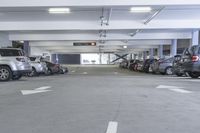 a group of cars sit in the parking lot in an indoor space with white walls