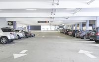 a group of cars sit in the parking lot in an indoor space with white walls