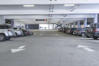 a group of cars sit in the parking lot in an indoor space with white walls