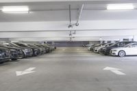 a group of cars sit in the parking lot in an indoor space with white walls