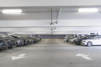 a group of cars sit in the parking lot in an indoor space with white walls