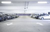 a group of cars sit in the parking lot in an indoor space with white walls