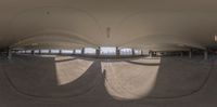 a view of inside of an indoor parking space with curved ceilings and multiple circular lights