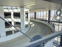 an indoor racing track for vehicles going through a building near buildings that are being used