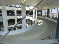 an indoor racing track for vehicles going through a building near buildings that are being used