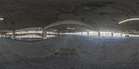 an indoor skateboard park is under construction with concrete walls and exposed beams above and below the ramp