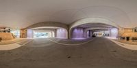 a view of inside an indoor skatepark at a park with the ramp down the front and back