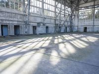 a large abandoned factory or industrial building with windows and a skateboarder riding through a tunnel