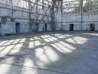 a large abandoned factory or industrial building with windows and a skateboarder riding through a tunnel