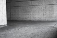 a man riding his skateboard in an old concrete parking garage with high rise walls