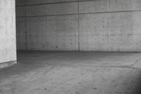 a man riding his skateboard in an old concrete parking garage with high rise walls