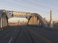 an industrial bridge crossing into the city skyline in the evening light with power lines over the road