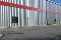 an industrial building with a red roof sits next to the street in front of the building