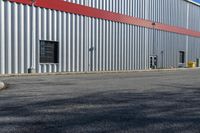 an industrial building with a red roof sits next to the street in front of the building