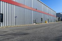 an industrial building with a red roof sits next to the street in front of the building