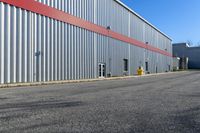 an industrial building with a red roof sits next to the street in front of the building