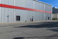 an industrial building with a red roof sits next to the street in front of the building