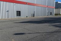 an industrial building with a red roof sits next to the street in front of the building