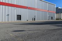 an industrial building with a red roof sits next to the street in front of the building