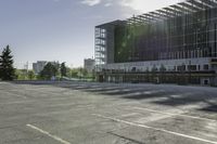 a empty parking lot with trees, buildings and sky in the background of this photograph