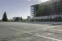 a empty parking lot with trees, buildings and sky in the background of this photograph