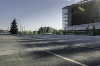 a empty parking lot with trees, buildings and sky in the background of this photograph