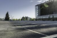 a empty parking lot with trees, buildings and sky in the background of this photograph