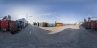 a fisheye picture of a large lot with some containers in it at the end