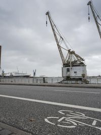 this is an image of a large crane on the street beside the water and the road