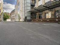 an empty building with signs on the street and people on bikes in traffic passing by