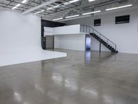 a commercial space features shiny concrete floors and white walls and ceilings with white lights in an industrial facility