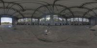 an oval mirror shows the inside of an indoor facility with a skateboard ramp below