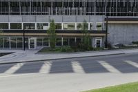 the shadows of a bike rider pass by this building on a quiet street in a city