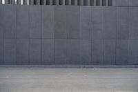 a person wearing a face mask walking across an empty street with a skateboard in the foreground