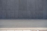 a person wearing a face mask walking across an empty street with a skateboard in the foreground