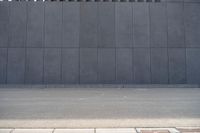 a person wearing a face mask walking across an empty street with a skateboard in the foreground