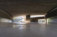 a skateboarder is riding under an open concrete roof on a slope above another building