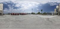 a group of red trucks parked next to each other near grain silos on the ground