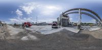 the view in the fish eye of two trucks, parked at the loading facility, and the loading station of an oil processing plant