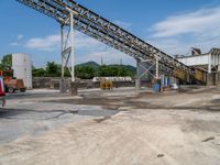 an industrial quarry with cement making equipment in it's pit area on a partly cloudy day