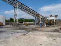 an industrial quarry with cement making equipment in it's pit area on a partly cloudy day