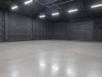 a hangar room with metal walls and lots of windows with recess lighting on the ceiling