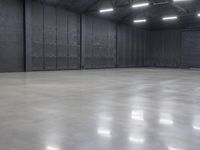 a hangar room with metal walls and lots of windows with recess lighting on the ceiling