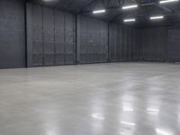 a hangar room with metal walls and lots of windows with recess lighting on the ceiling