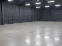 a hangar room with metal walls and lots of windows with recess lighting on the ceiling