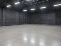 a hangar room with metal walls and lots of windows with recess lighting on the ceiling